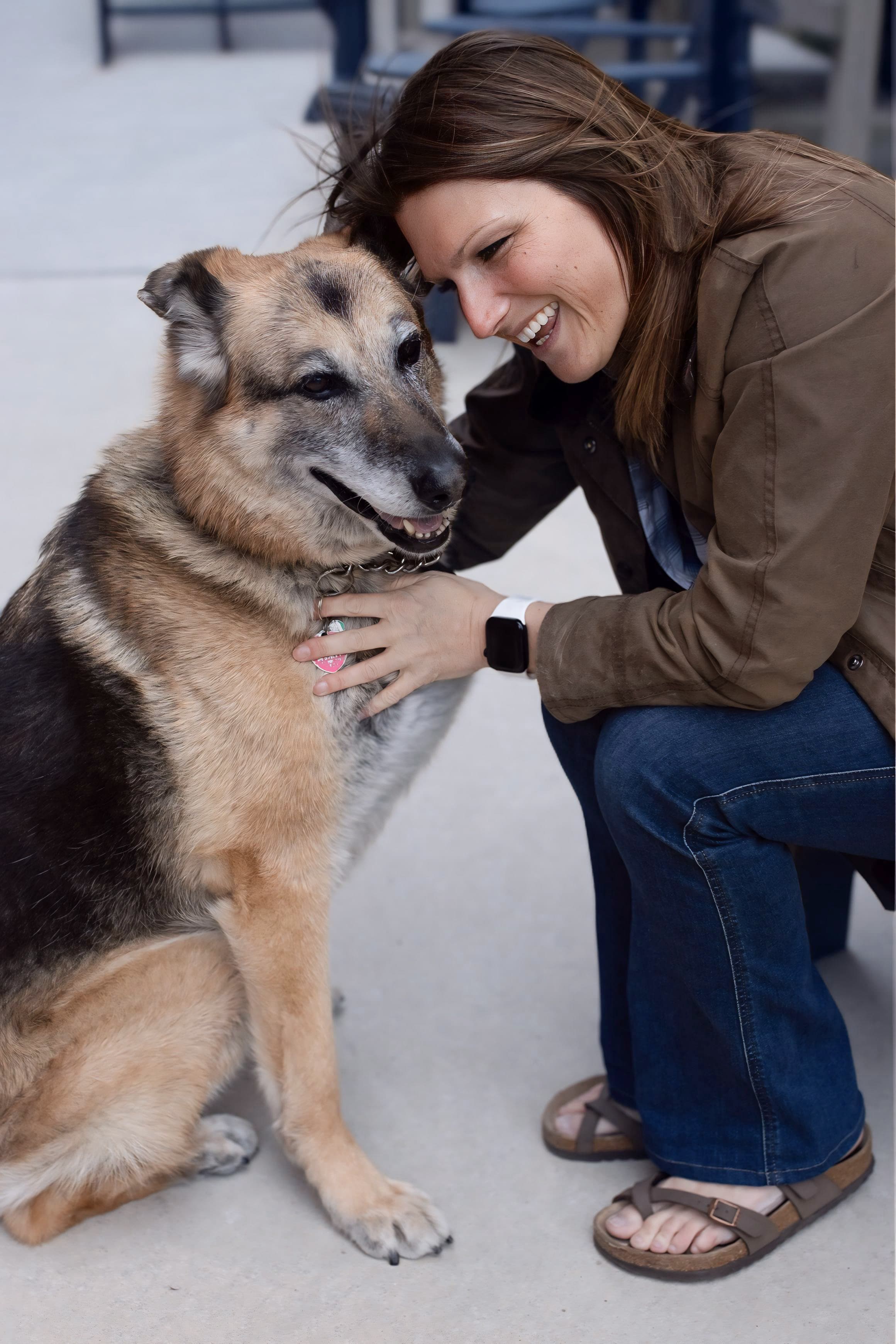 Owner laughing face-to-face with her senior German Shepherd
